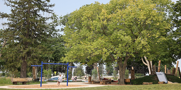 A woman and a child on the swings at a park