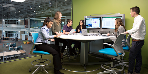 A group of interns gathered around a table working together