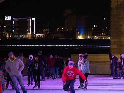 Group ice skating at night in Downtown DSM